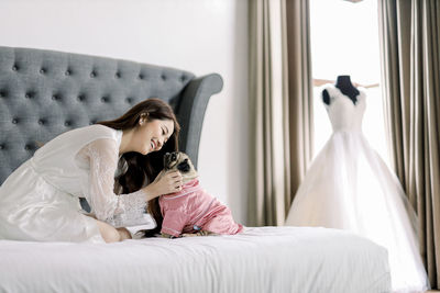 Low angle view of woman sitting on bed