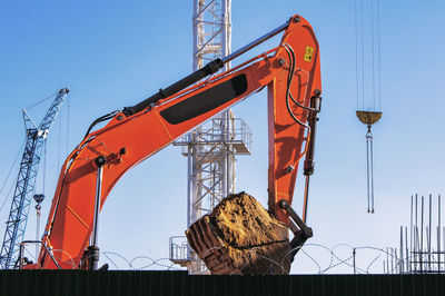 Boom bucket excavator with sand construction site