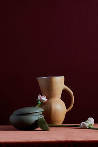 Handmade pottery and flowers on rich colored background