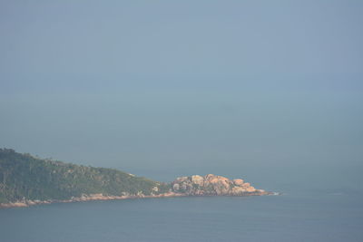 Scenic view of sea and mountains against clear sky