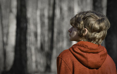 Rear view of woman standing against trees