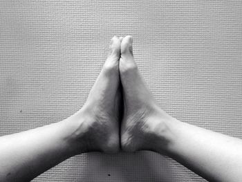 Low section woman practicing butterfly pose yoga on exercise mat