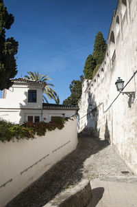 Street amidst buildings against blue sky