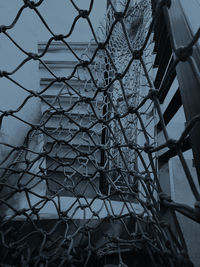 Low angle view of chainlink fence against sky during sunset