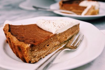 Slice of pumpkin pie served in plate on table