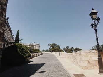Street amidst trees against clear sky