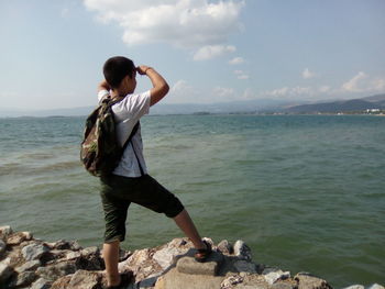 Full length of boy looking at sea against sky