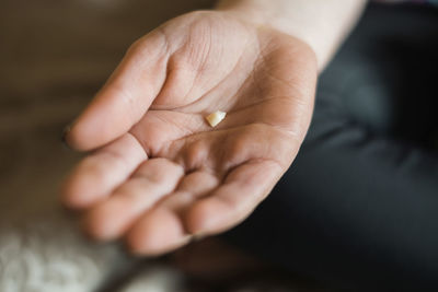 Closeup of a child's hand holding a baby tooth