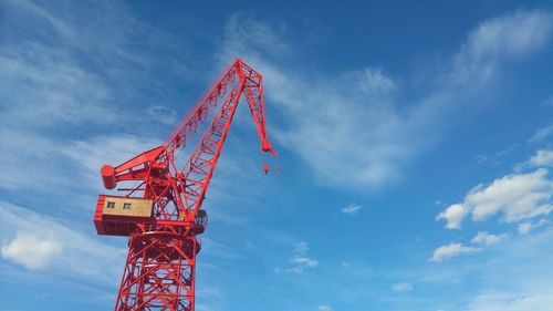 Low angle view of crane against blue sky