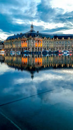 Sailboats in sea against buildings in city