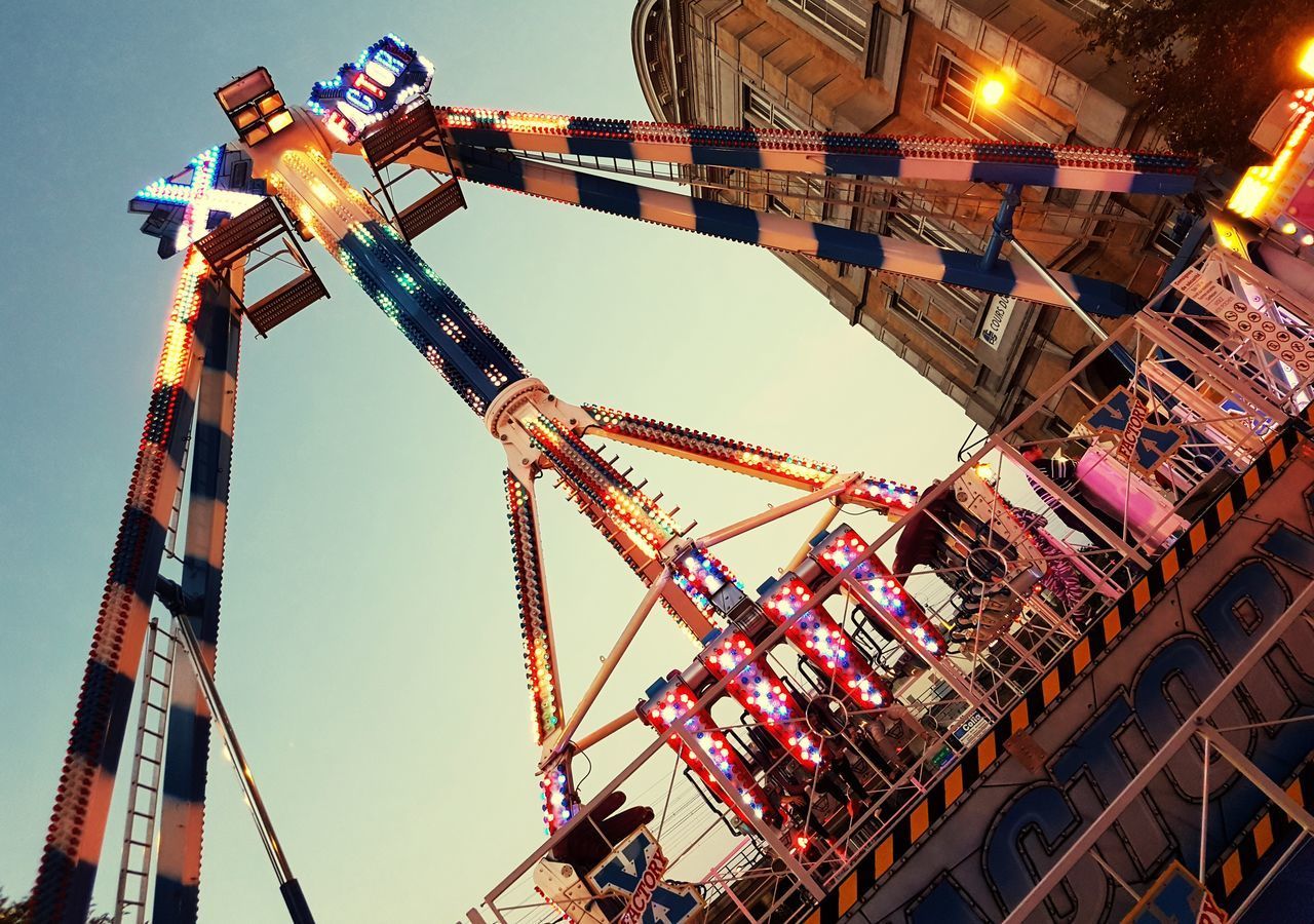 LOW ANGLE VIEW OF ILLUMINATED CAROUSEL AGAINST SKY