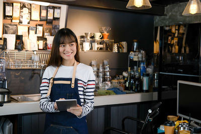 Portrait of a smiling young woman using phone