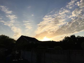 Built structures against sky at sunset