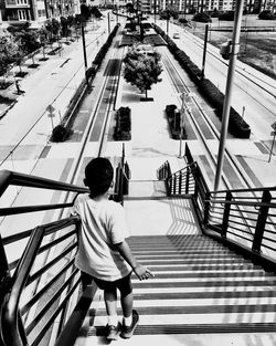 Rear view of boy standing on steps at park