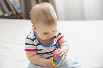 Portrait of cute boy playing with toys on floor at home