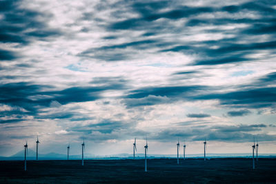 Several wind turbines with interesting sky and mountains in the distance