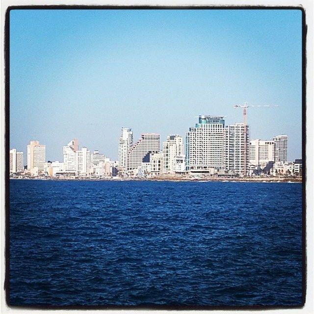 building exterior, architecture, built structure, city, blue, waterfront, water, cityscape, transfer print, clear sky, skyscraper, urban skyline, copy space, tower, river, auto post production filter, skyline, sea, sky, tall - high