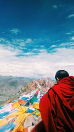 Rear view of man looking at mountain against sky