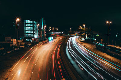 Light trails on road against sky at night