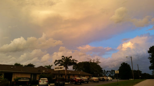 Cars on road against cloudy sky