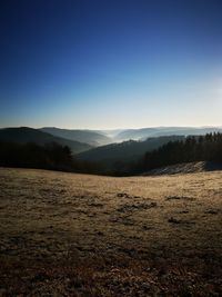 Sunrise with fog in valley behind open field