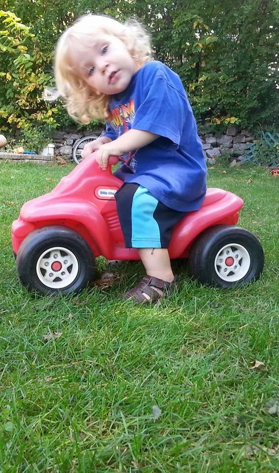 childhood, grass, child, full length, plant, field, real people, casual clothing, day, mode of transportation, land, toy, one person, leisure activity, toy car, nature, females, car, transportation, innocence, outdoors, tire, wheel