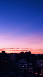 High angle view of silhouette buildings against sky at sunset