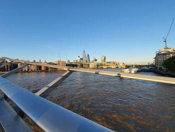 Bridge over river against buildings in city