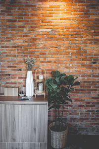 Potted plant against brick wall at home