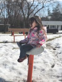 Rear view of girl standing on snow covered landscape