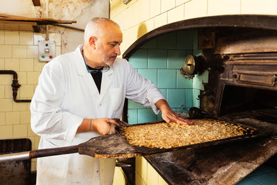 Midsection of man preparing food in workshop