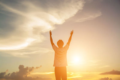 Rear view of silhouette person standing against sky during sunset