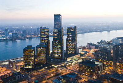 High angle view of city lit up at waterfront