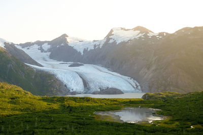 Scenic view of lake and snowcapped mountains against sky