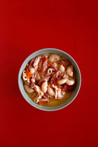 Directly above shot of dessert in bowl against red background