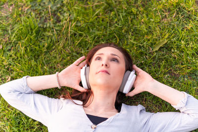 Portrait of young woman using mobile phone in grass