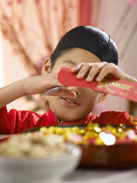 Close-up of teenage boy in traditional clothes holding money