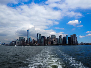 City skyline by sea against sky