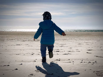 Toddler running on the beach. 