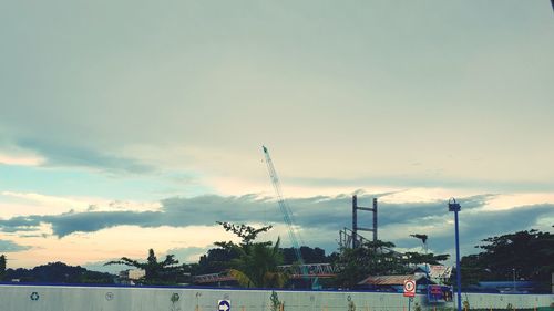 Cars on street against sky during sunset