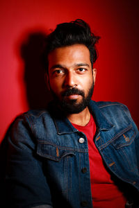 Portrait of young man standing against yellow background