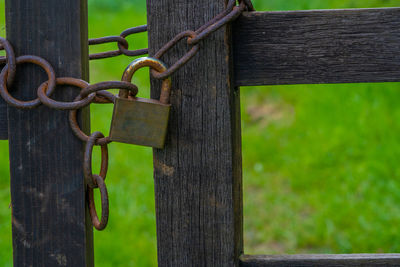 Close-up of rusty chain hanging on fence