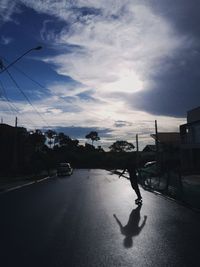 Man riding motorcycle on street in city against sky