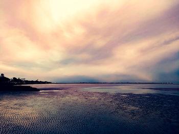 Scenic view of beach against sky during sunset