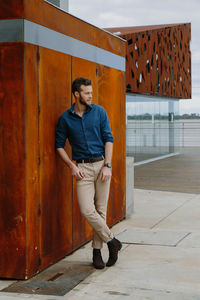 Full length of young man standing against wall