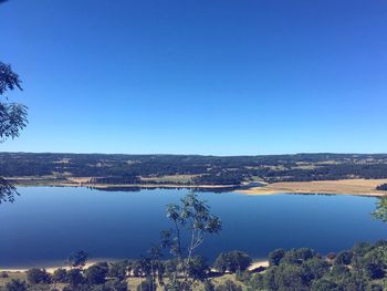 Scenic view of lake against clear blue sky