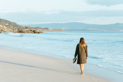 Rear view of woman walking on beach