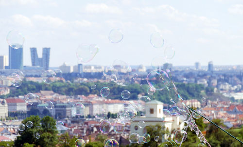 View of bubbles in city against sky