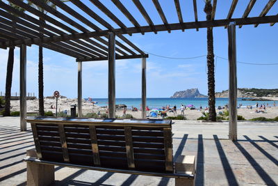 Chairs and table on beach against sky