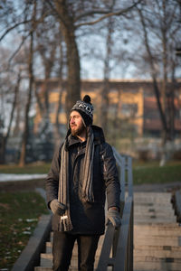 Young man in warm clothing moving down on steps at park